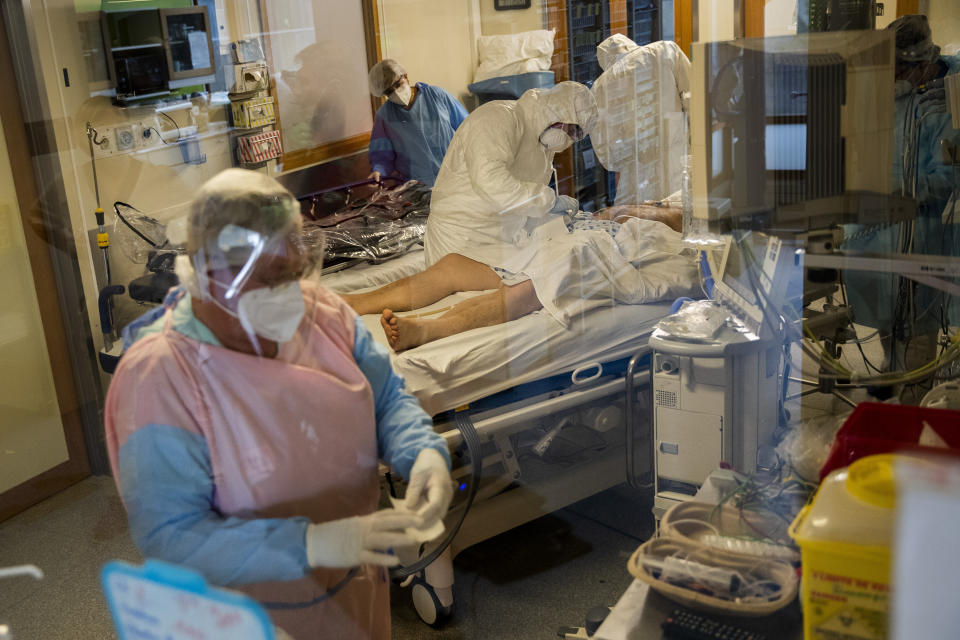 Medical personnel wearing protective equipment work with a coronavirus patient who will be transferred by helicopter from the COVID-19 intensive care unit of the CHU Liege hospital to another hospital in Germany, in Liege, Belgium, Tuesday, Nov. 3 , 2020. (AP Photo/Francisco Seco)