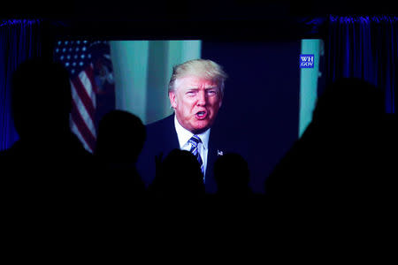 Guests watch a video of U.S. President Donald Trump as he addresses the 15th Plenary Assembly of the World Jewish Congress in New York City, U.S., April 23, 2017. REUTERS/Brendan McDermid