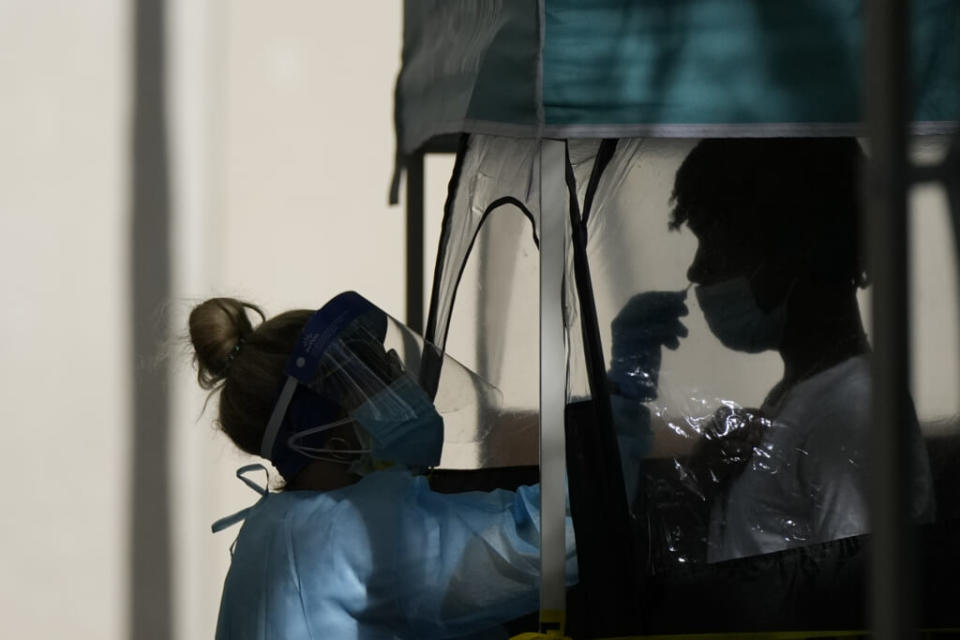 A man is tested for COVID-19, at a walk-up testing site run by Nomi Health, Tuesday, Dec. 28, 2021, in downtown Miami. (AP Photo/Rebecca Blackwell)