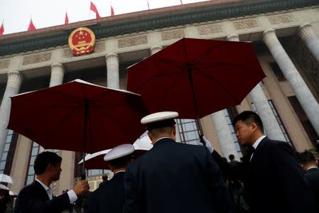 Security officers stand guard outside the Great Hall of the People as delegates arrive for the opening of the 19th National Congress of the Communist Party of China in Beijing, China October 18, 2017. REUTERS/TyroneÊSiu