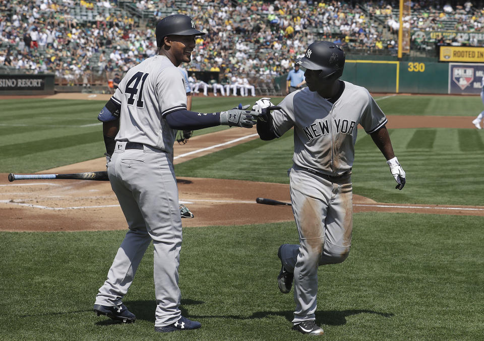 New York Yankees' Andrew McCutchen, right, is congratulated by Miguel Andujar after scoring against the Oakland Athletics during the first inning of a baseball game in Oakland, Calif., Monday, Sept. 3, 2018. (AP Photo/Jeff Chiu)