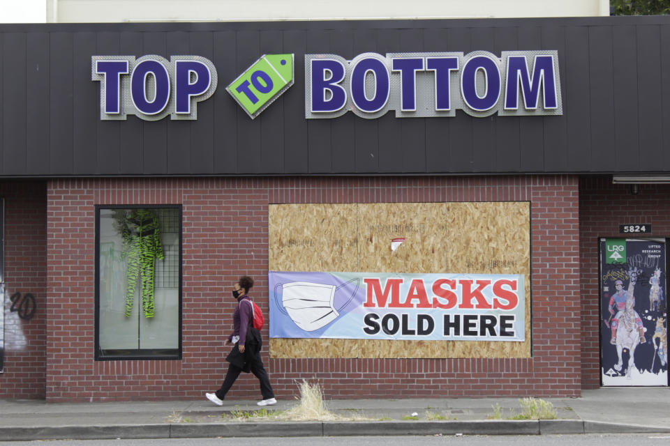 A pedestrian walks past a business damaged during recent protests on Wednesday, July 1, 2020, in North Portland, a historically Black neighborhood in Oregon. Thousands of protesters in the liberal and predominantly white city have taken to the streets peacefully every day for more than five weeks to decry police brutality, but recent violence by smaller groups is creating a deep schism in the protest movement. As demonstrations enter their second month, they have shifted to a historically Black neighborhood in North Portland. (AP Photo/Gillian Flaccus)