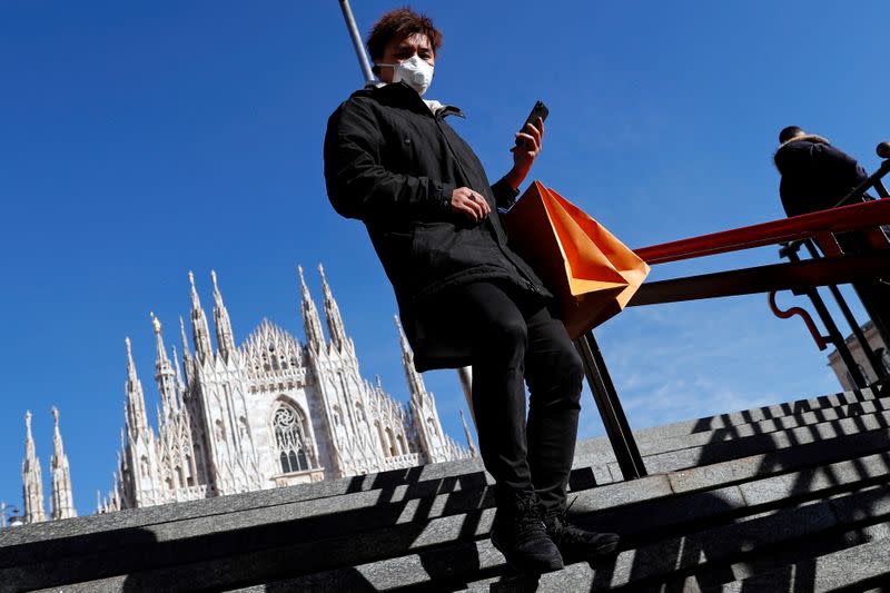 A man wearing a protective face mask to prevent contracting the coronavirus enters a subway station in Milan