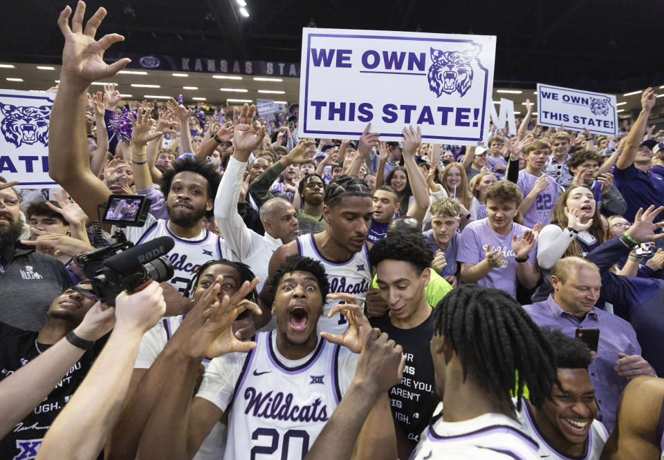 Kansas State players, including Jerrell Colbert (20), celebrate with fans after the team defeated rival Kansas in an NCAA college basketball game, Monday, Feb. 5, 2024, in Manhattan, Kan. (Travis Heying/The Wichita Eagle via AP)