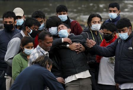 Family members cry over the body of one of their family member, who died in Saturday's earthquake, during the cremation along a river in Kathmandu, Nepal April 28, 2015. REUTERS/Adnan Abidi