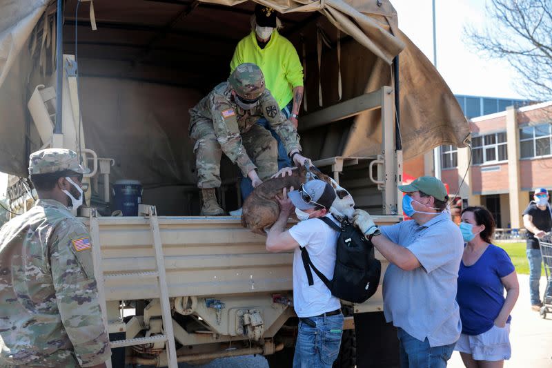 A Michigan National Guard hands a pet to the owner after they were evacuated to an emergency shelter during the flooding along the Tittabawassee River, after several dams breached, in Midland,