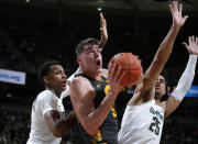 Iowa's Luka Garza, center, looks for a shot between Michigan State's Marcus Bingham Jr., left, and Malik Hall (25) during the first half of an NCAA college basketball game, Tuesday, Feb. 25, 2020, in East Lansing, Mich. (AP Photo/Al Goldis)