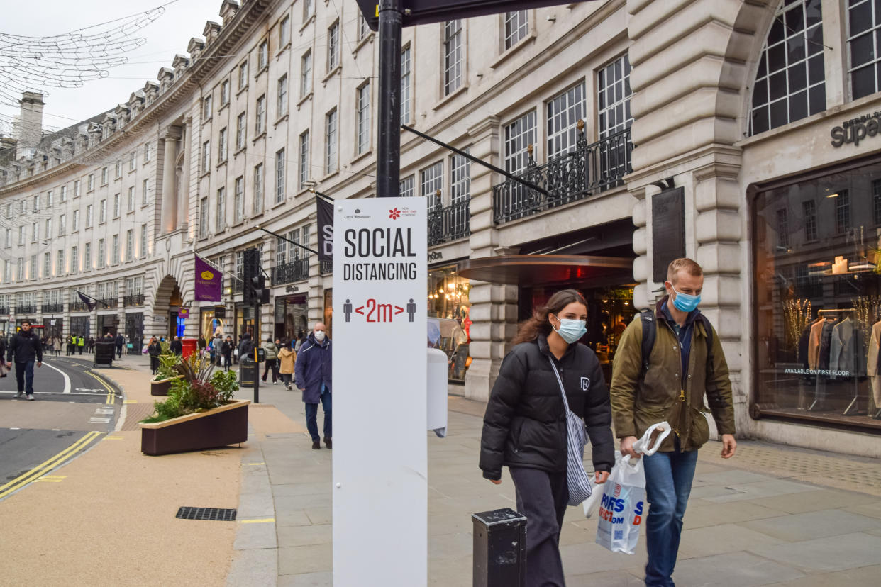  People wearing face masks walk past a social distancing sign on Regent Street, which was blocked for vehicle traffic for a day. London has seen an increase in coronavirus cases, prompting fears that tougher restrictions may be introduced once again. (Photo by Vuk Valcic / SOPA Images/Sipa USA) 