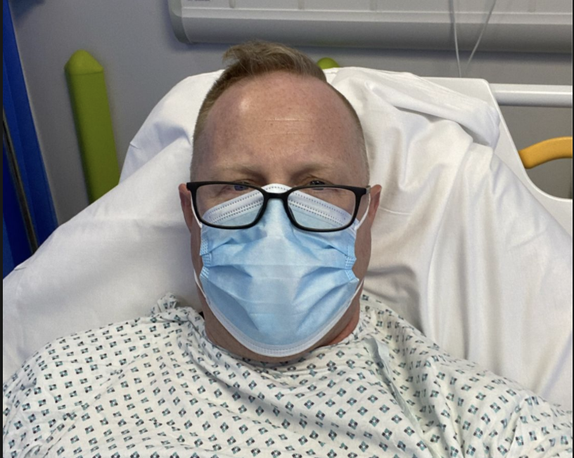 Jonathan Frostick wearing a mask in his hospital bed. 