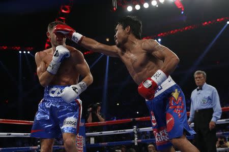 Manny Pacquiao (R) of the Philippines punches Chris Algieri of the U.S. during their World Boxing Organisation (WBO) 12-round welterweight title fight at the Venetian Macao hotel in Macau November 23, 2014. REUTERS/Tyrone Siu