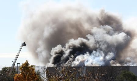 Smoke billows from a building at at Mid-Continent Airport shortly after a twin-turbo airplane crashed into a building, killing several people, including the pilot in Wichita, Kansas October 30, 2014. REUTERS/Brian Corn/Wichita Eagle/MCT