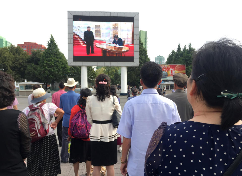 In this Wednesday, Sept. 19, 2018, file photo, residents of Pyongyang, North Korea gather in a plaza outside the city’s main train station to watch the news of South Korean President Moon Jae-in’s visit. Though images of Moon’s arrival had been aired around the world the day before, the first footage was delayed by a day in the North. (AP Photo/Eric Talmadge, File)