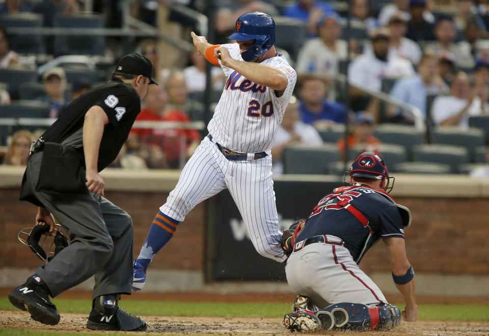 NEW YORK, NEW YORK - JUNE 30:   Pete Alonso #20 of the New York Mets avoids the tag from Tyler Flowers #25 of the Atlanta Braves to score a run in the third inning at Citi Field on June 30, 2019 in New York City. (Photo by Jim McIsaac/Getty Images)