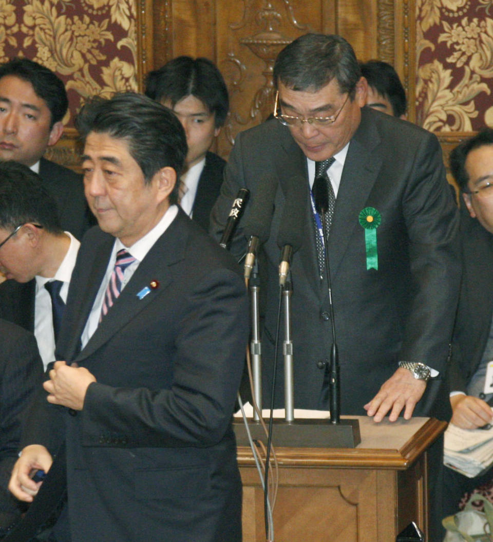 Japan's Prime Minister Shinzo Abe walks by public broadcaster NHK President Katsuto Momii speaking during a budget committee question and answer at the lower house of Parliament in Tokyo Wednesday, Feb. 5, 2014. Prime Minister Shinzo Abe’s appointment of new board members at Japan’s public broadcaster NHK has invited skepticism among many people that his motive may be to use the news giant to promote his nationalist agenda. Sure enough, minutes of a recent NHK governing board meeting suggest they were trying to exercise influence over programs. (AP Photo/Kyodo News) JAPAN OUT, MANDATORY CREDIT