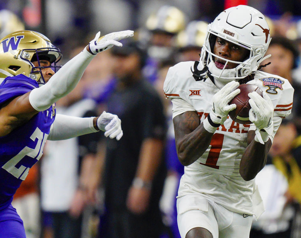 FILE - Texas wide receiver Xavier Worthy (1) makes a catch while covered by Washington cornerback Elijah Jackson, left, during the Sugar Bowl CFP NCAA semifinal college football game Jan. 1, 2024, in New Orleans. While Ohio State’s Marvin Harrison Jr. will most assuredly be gone the Buffalo Bills' scheduled NFL draft pick at No. 28, the Texas junior tandem of Adonai Mitchell and Worthy, or perhaps Georgia’s Ladd McConkey, could be available. (AP Photo/Jacob Kupferman, File)