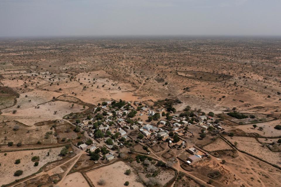 The brown landscape dotted with trees around the village of Ndiawagne Fall in Kebemer, Senegal,