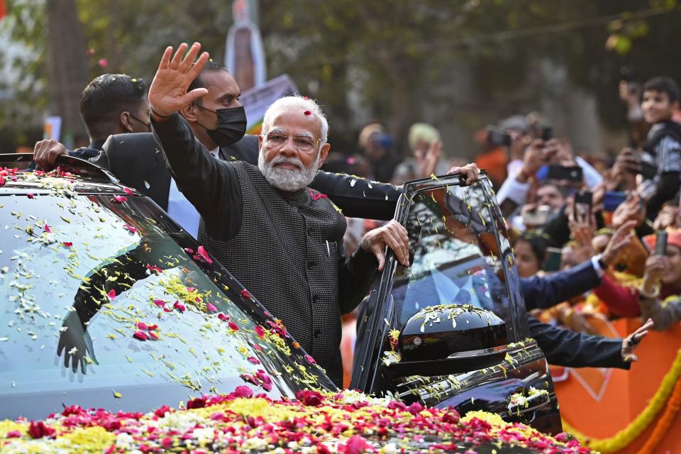 India's Prime Minister Narendra Modi (C) waves to his supporters during a roadshow ahead of the BJP national executive meet in New Delhi on January 16, 2023