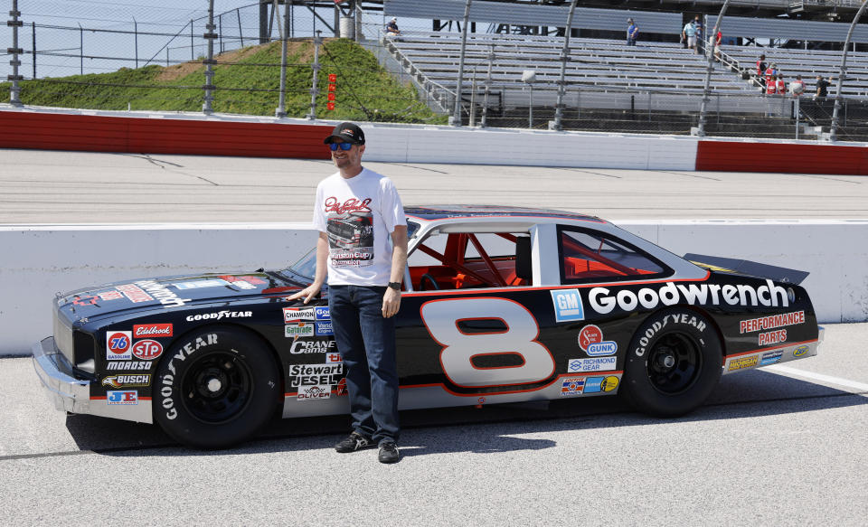 Dale Earnhardt Jr. stands by the car he will drive in pre-race activities before the NASCAR Xfinity Series auto race at Darlington Raceway, Saturday, May 8, 2021, in Darlington, S.C. The car is a Chevy Nova that his father drove in what is now the Xfinity Series. (AP Photo/Terry Renna)