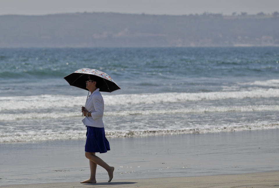 In this May 22, 2012 photo, a woman walks barefoot along the Coronado Beach in Coronado, Calif. The Coronado Beach has been named America's best beach. Coronado Beach tops the 2012 list of Top 10 Beaches produced annually by coastal expert Stephen P. Leatherman, also known as "Dr. Beach," director of Florida International University's Laboratory for Coastal Research. (AP Photo/Lenny Ignelzi)