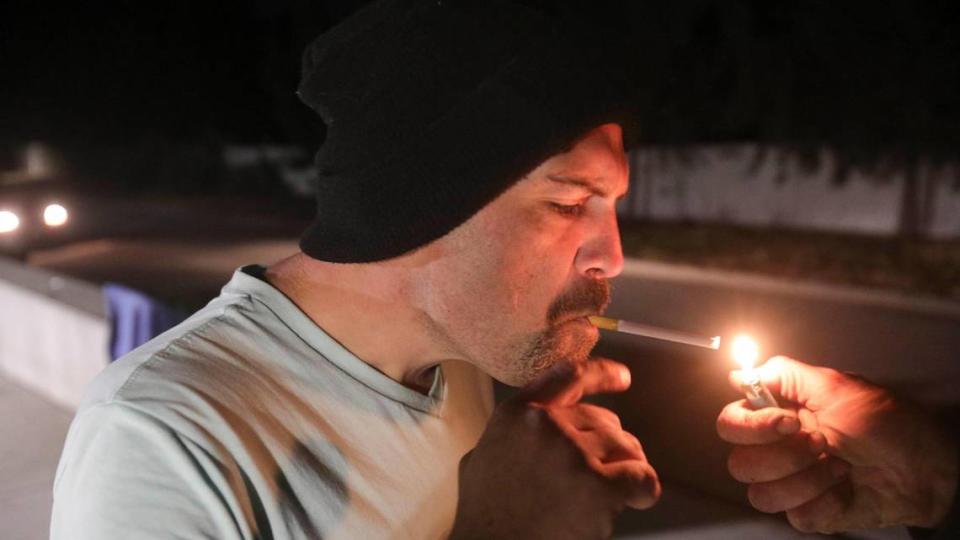 Patrick Smith gets a light for his cigarette before going into the 40 Prado Homeless Services Center in San Luis Obispo on Nov. 29, 2023. The CAPSLO facility opens a warming shelter when temperatures fall or rain is in the forecast.