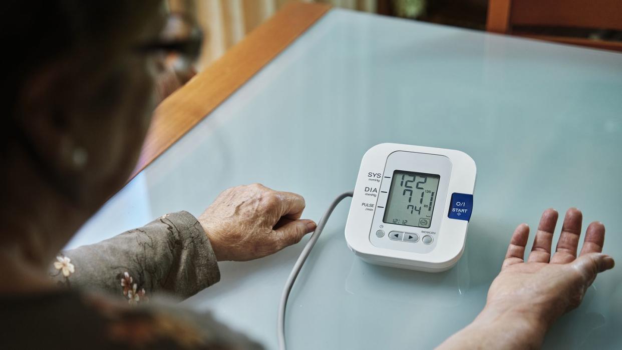 senior woman examining her blood pressure on her arm