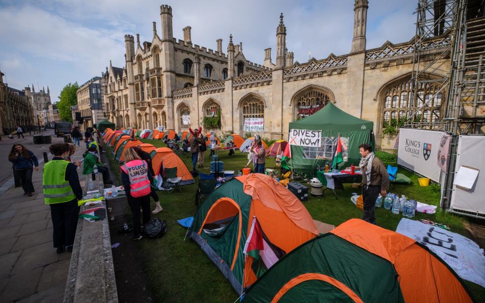 Historic walls of Kings College, Cambridge lined with Palestinian flags and banners painted with messages including "divest from genocide" and "occupation is a crime"