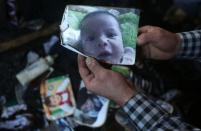 A man shows a picture of 18-month-old Palestinian toddler Ali Saad Dawabsha who died when his family house was set on fire by Jewish settlers in the West Bank village of Duma on July 31, 2015