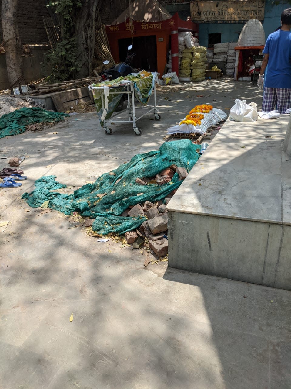 A dead body lying on the ground as over a dozen pyres burn inside the cremation ground during the second Covid waveStuti Mishra