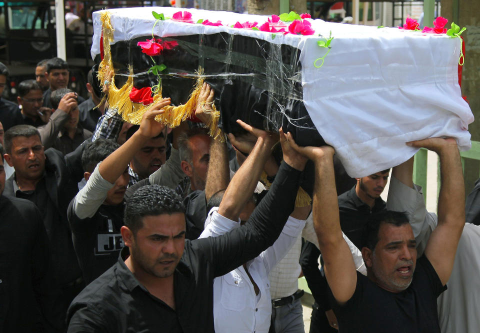 Mourners chant slogans against the al-Qaida breakaway group Islamic State of Iraq and the Levant (ISIL), while carrying a flag-draped coffin of Shawki Rahim during his funeral procession in Najaf, 100 miles (160 kilometers) south of Baghdad, Iraq, Thursday, April 17, 2014. The Iraqi Army officer was killed during clashes with al-Qaida fighters in Hillah last night, his family said. (AP Photo/Jaber al-Helo)