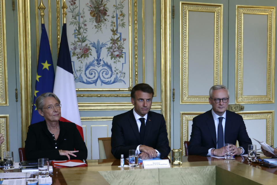 French President Emmanuel Macron, center, French Prime Minister Elisabeth Borne, left, and Economy Minister Bruno Le Maire attend a government emergency meeting at the emergency crisis center of the Interior Ministry in Paris, Sunday, July 2, 2023 after a 17-year-old whose killing by police has triggered days of rioting and looting across the nation. (Mohamed Badra, Pool via AP)