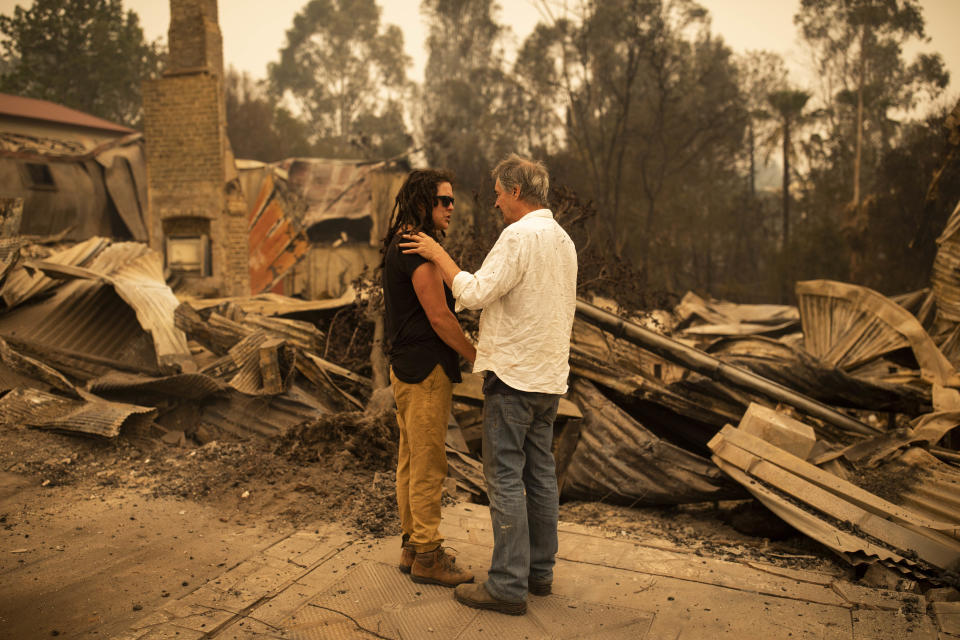 Sally Anne Wilson (left) stands in front of her destroyed Cobargo shop with partner Christopher Lee.