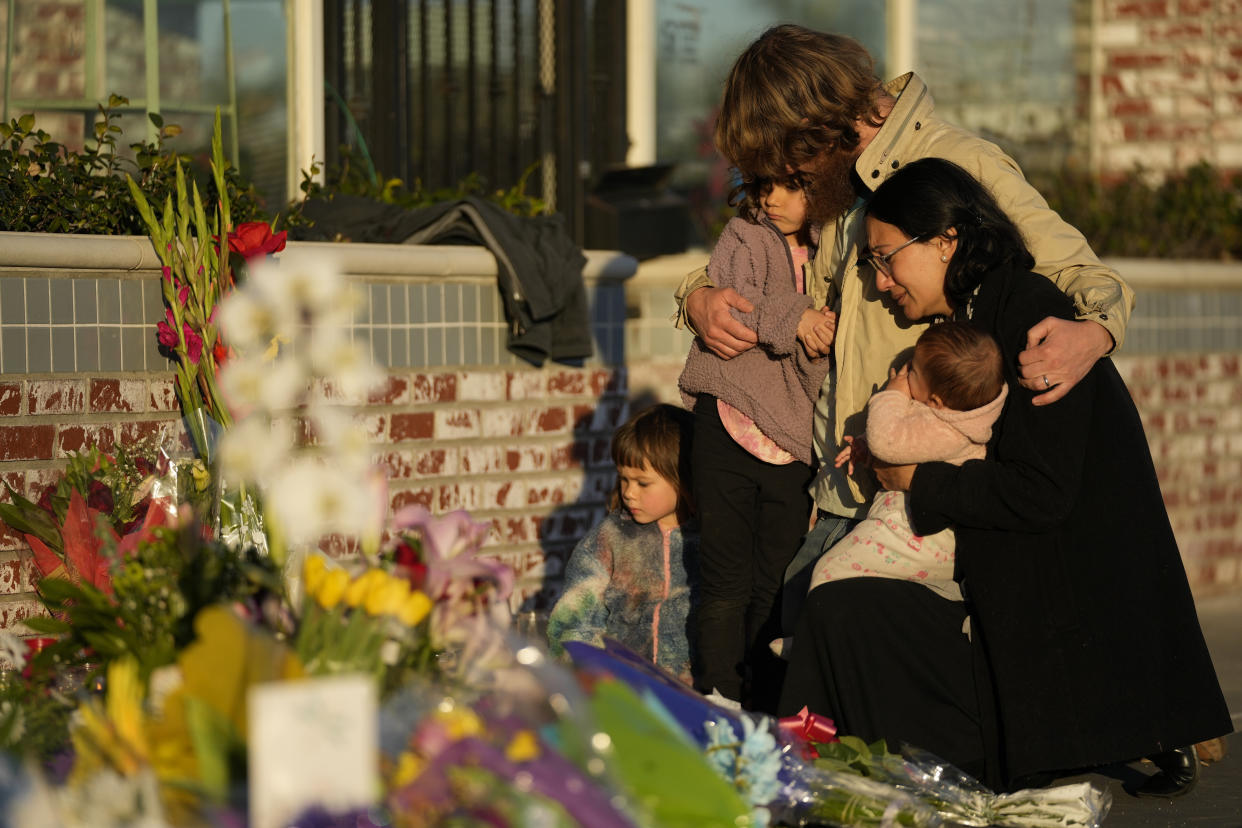 A family gathers at a memorial outside the Star Ballroom Dance Studio on Tuesday, Jan. 24, 2023, in Monterey Park, Calif. A gunman killed multiple people at the ballroom dance studio late Saturday amid Lunar New Years celebrations in the predominantly Asian American community. (AP Photo/Ashley Landis)