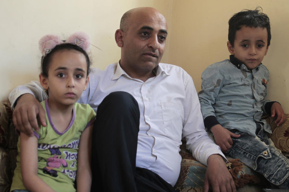 Anwar Alsaeedi sits with his children at his home in Sanaa, Yemen, Thursday, Jan. 28, 2021. Alsaeedi, who had hoped to provide his two children with a better future, said he rejoiced in 2017 when he was picked for the lottery’s “diversity visa” interview. Then he was ineligible due to the Trump administration’s travel ban that affected several Muslim-majority nations. “Our country is embroiled in wars and crises and we’ve lost everything,” he said. “Making it to America is a big dream.” (AP Photo/Hani Mohammed)