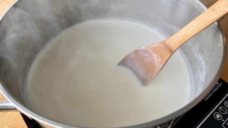 whisking milk mixture in pot