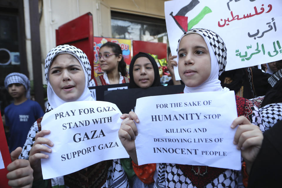 Palestinian students hold placards during a protest in solidarity with the Palestinian people in Gaza, at the Palestinian refugee camp of Ein el-Hilweh, south Lebanon, Wednesday, Oct. 18, 2023. (AP Photo/Mohammed Zaatari)