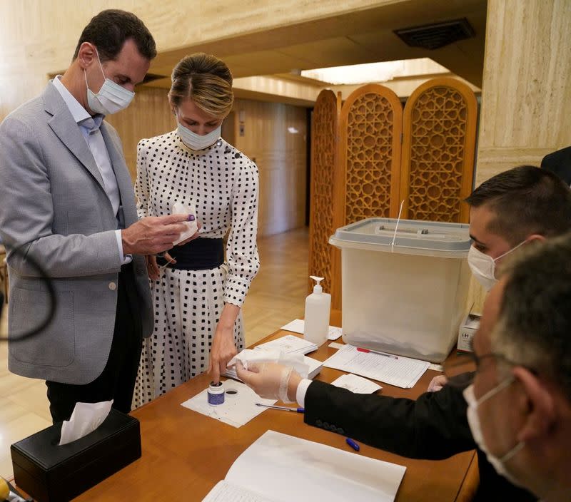 FILE PHOTO: Syria's President Bashar al-Assad and his wife Asma cast their vote inside a polling station during the parliamentary elections in Damascus