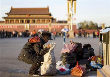 A man collects waste bottles at Tiananmen Square in central Beijing, December 4, 2013. REUTERS/Stringer/Files