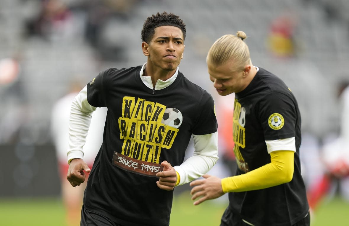 FILE – Dortmund’s Jude Bellingham, left, and Erling Haaland wear t-shirts bearing an anti-racism message prior to the German Bundesliga soccer match between Borussia Dortmund and FSV Mainz 05 in Dortmund, Germany, Saturday, Oct. 16, 2021. The manifestation of a deeper societal problem, racism is a decades-old issue in soccer — predominantly in Europe but seen all around the world — that has been amplified by the reach of social media and a growing willingness for people to call it out. (AP Photo/Martin Meissner, File)