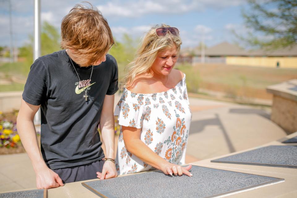 Ashley Sylvester and son Jacob Sylvester on April 14 find the name of her late husband, Sgt. Jason A Sylvester, on the Veterans Wall of Honor in Moore.