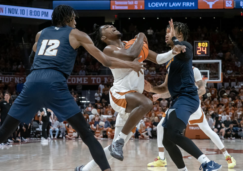 Texas guard Marcus Carr, center, drives to the basket between UTEP forward Jamari Sibley, left, and guard Malik Zachery during the second half an NCAA college basketball game Monday, Nov. 7, 2022, in Austin, Texas. Texas won 72-57. (AP Photo/Michael Thomas)