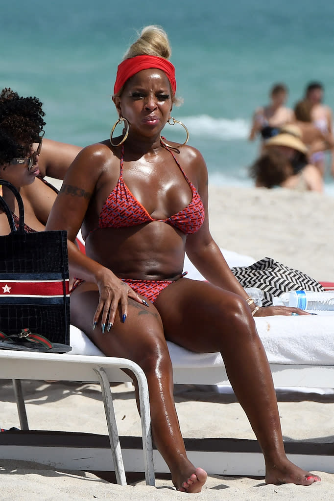 Mary J. Blige wearing a red and black Versace bikini while on a beach in Mi...