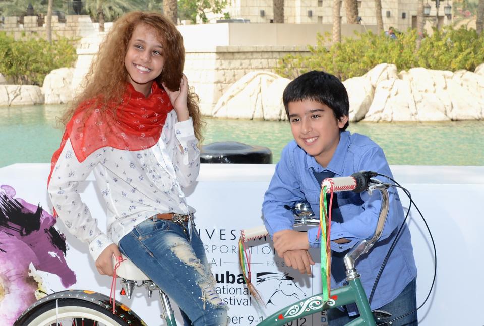 DUBAI, UNITED ARAB EMIRATES - DECEMBER 12: Actors Waad Mohammed and Abdulrahman al Guhani attend the "Wadjda" photocall during day four of the 9th Annual Dubai International Film Festival held at the Madinat Jumeriah Complex on December 12, 2012 in Dubai, United Arab Emirates. (Photo by Andrew H. Walker/Getty Images for DIFF)