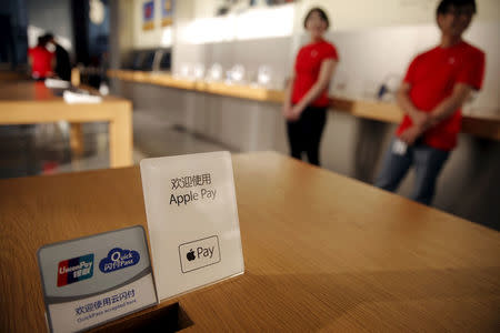 Signs are placed on the table as employees demonstrate to reporters how to pay using the Apple Pay service at an Apple store in Beijing, China, February 17, 2016.REUTERS/Damir Sagolj/File Photo