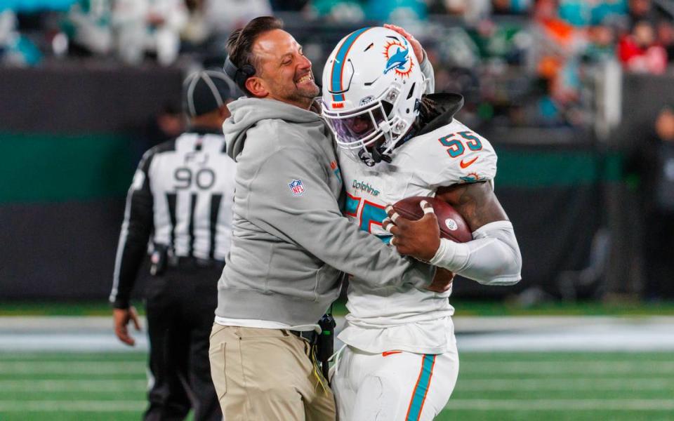 Miami Dolphins linebacker Jerome Baker (55) celebrates with Dolphins linebackers coach Anthony Campanile after intercepting a pass during fourth quarter of an NFL football game against the New York Jets at MetLife Stadium on Friday, Nov. 24, 2023 in East Rutherford, New Jersey.