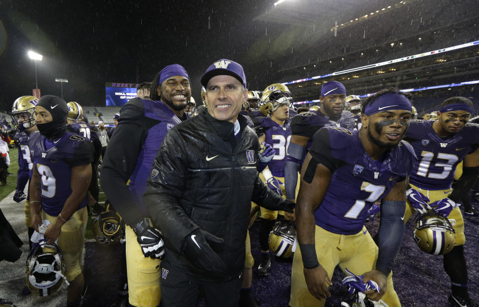 Washington head coach Chris Petersen, center, leads his team off the field after they beat Oregon 38-3 in an NCAA college football game, Saturday, Nov. 4, 2017, in Seattle. Washington won, 38-3. (AP Photo/Ted S. Warren)