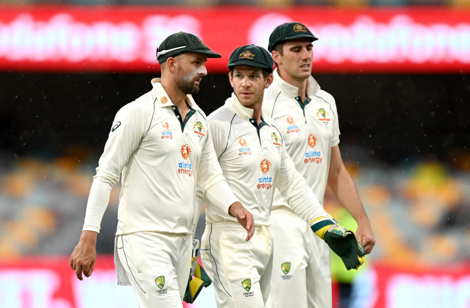 Tim Paine (pictured middle) walks off the field with teammates.