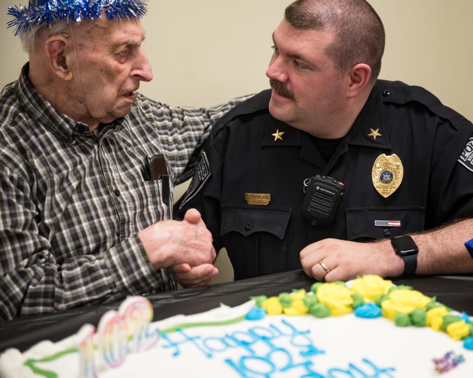 New York Mills Police Chief Robert Frankland shakes the hand of Stanley Potrzeba during his 102nd birthday party at the New York Mills Community Center on Tuesday, May 14, 2024.