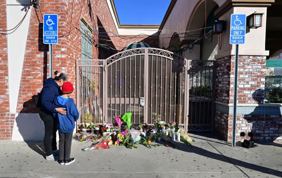 Inez Arakaki comforts her son Zachary as they visit a makeshift memorial site in front of the Star Dance Studio in Monterey Park on Jan. 23, 2023, where 10 people were shot dead late on Jan. 21, 2023. (FREDERIC J. BROWN/AFP via Getty Images)