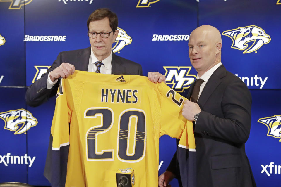 New Nashville Predators NHL hockey team head coach John Hynes, right, poses for photos with Predators general manager David Poile at a news conference Tuesday, Jan. 7, 2020, in Nashville, Tenn. The Predators hired Hynes, the former New Jersey Devils coach, as the third coach in franchise history after firing Peter Laviolette. (AP Photo/Mark Humphrey)