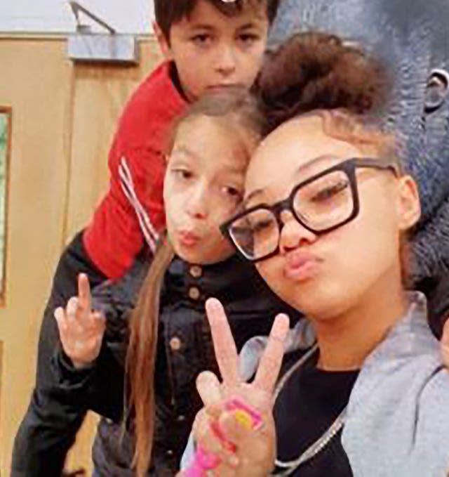 Khandi, 14, (right) making a peace sign next to Amelia, nine, (centre) and Malik, seven,